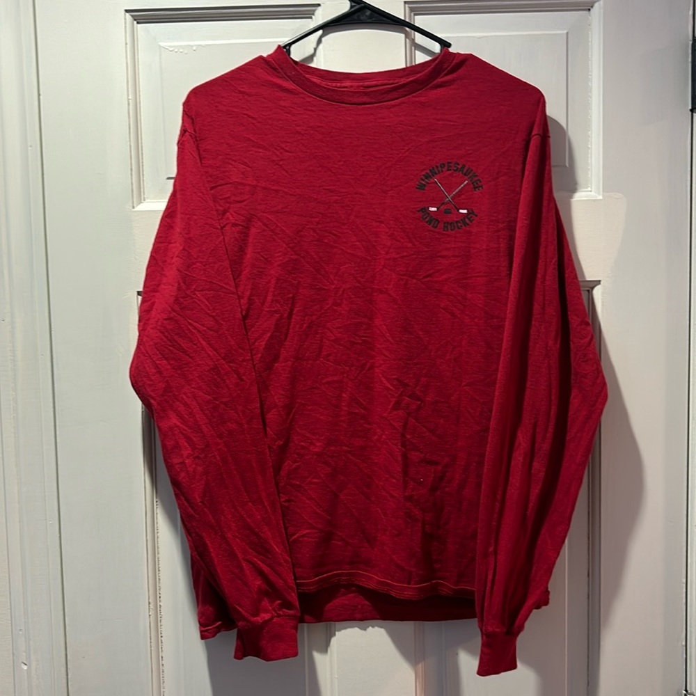 Red long sleeve hockey shirt with cuffs on the end of the sleeves.